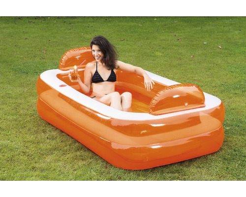 Piscine gonflable avec femme et boisson dans le jardin