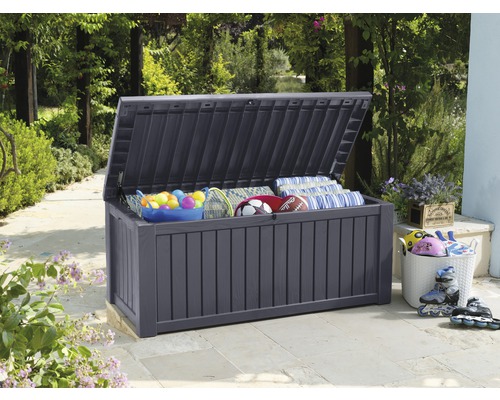 Coffre de rangement gris ouvert à l''extérieur avec des jouets et des coussins