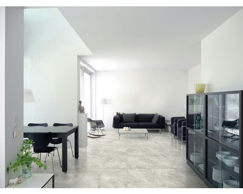 Helles Wohnzimmer mit Fliesenboden, Esstisch und Sofa