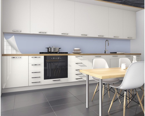 Cuisine claire avec protection anti-éclaboussures derrière la plaque de cuisson et table à manger avec chaises