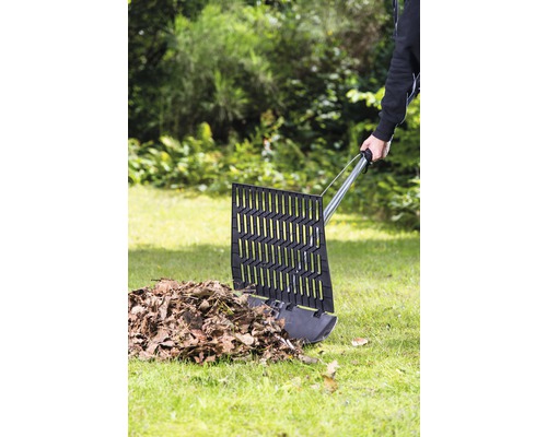 Pelle à feuilles ramassant des feuilles dans le jardin