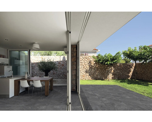 Blick durch eine geöffnete Schiebetür auf Terrasse, Garten und Wohnbereich