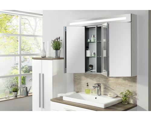 Badezimmer mit Waschbecken, Spiegelschrank, Unterschrank und Fenster für Tageslicht