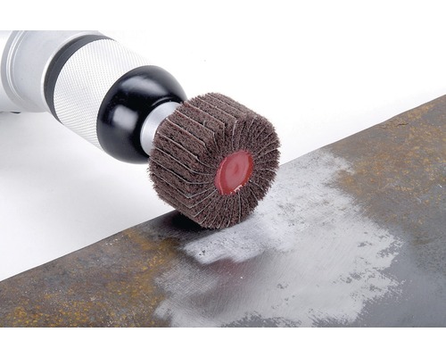 Meule à lamelles sur une perceuse en train de meuler du métal