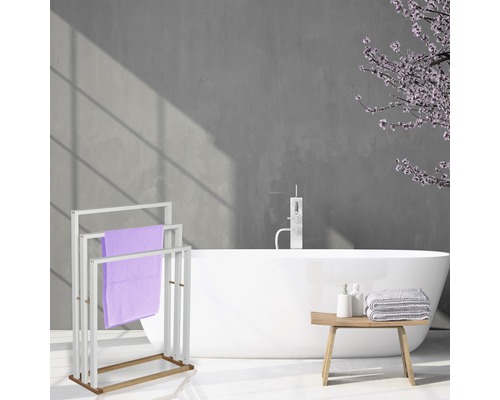 Badezimmer mit freistehender Badewanne, Handtuchständer und Handtüchern.