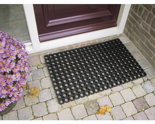 Tapis en caoutchouc noir devant une porte d''entrée