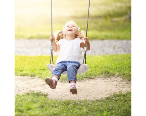 Fille sur une balançoire dans le jardin