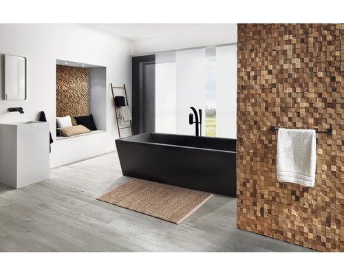 Badezimmer mit freistehender Badewanne, Waschtisch, Spiegel, Holzverkleidung und Dekoleiter