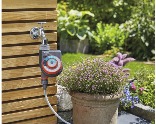 Gardena Bewässerungssteuerung am Wasserhahn mit Gartenhintergrund