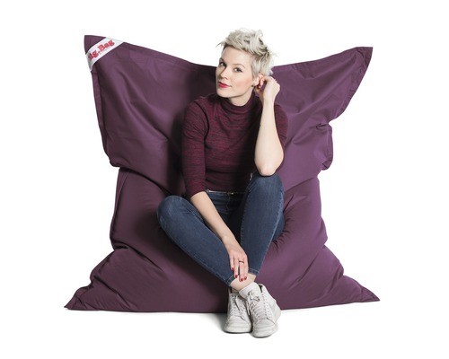 Femme assise sur un grand pouf violet