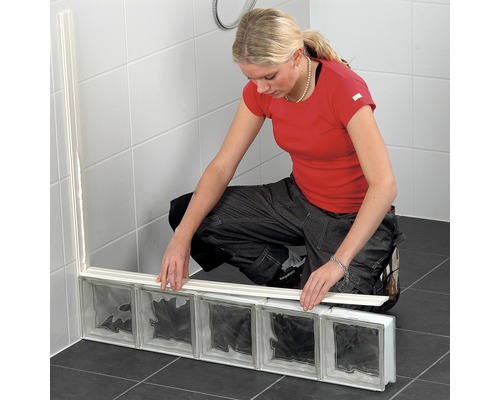 Frau montiert Glasbausteine im Badezimmer