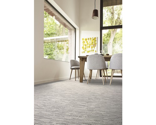 Esszimmer mit Teppichboden, Esstisch und Stühlen.