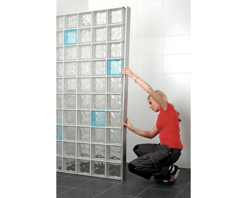 Frau installiert Glasbausteinwand im Badezimmer mit einigen farbigen Akzenten