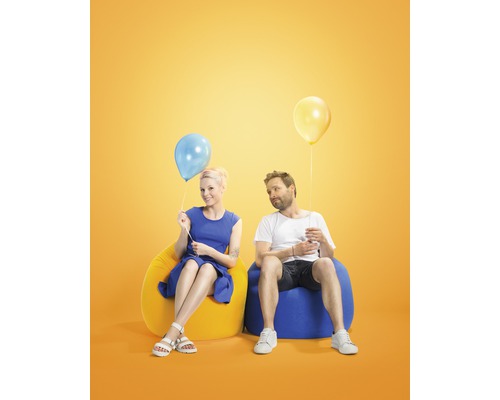 Un homme et une femme sont assis sur des poufs avec des ballons.