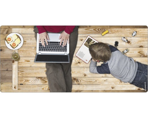 Szene mit einer Person, die einen Laptop benutzt, einem Kind, Spielzeug und Essen auf einer Holzoberfläche