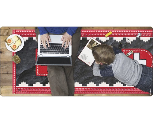 Person mit Laptop und Kind auf Spielteppich mit Schweizer Kreuz Motiv
