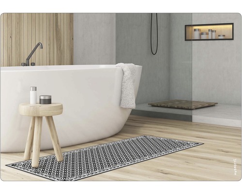 Badezimmer mit Badewanne, Hocker und gemusterter Badematte