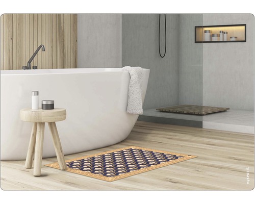 Badezimmer mit Badewanne, Hocker und einer dunkelblauen Badematte mit Muster