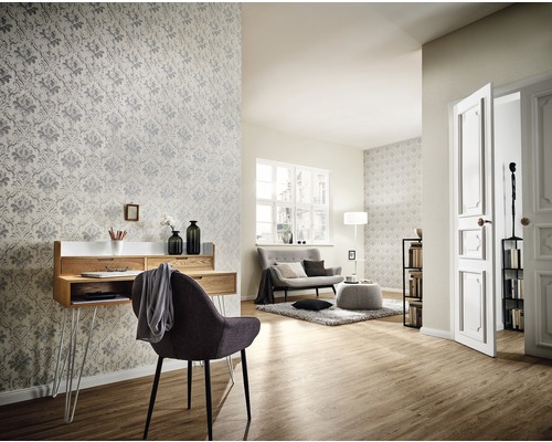 Salon avec bureau, chaise, canapé et papier peint à motifs