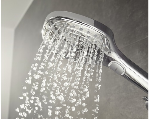 Douchette à main avec de l''eau qui coule dans la salle de bain