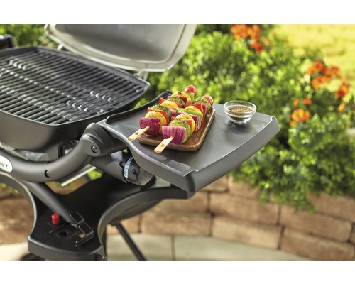 Barbecue avec brochettes de légumes et épices sur une table d''appoint dans le jardin.