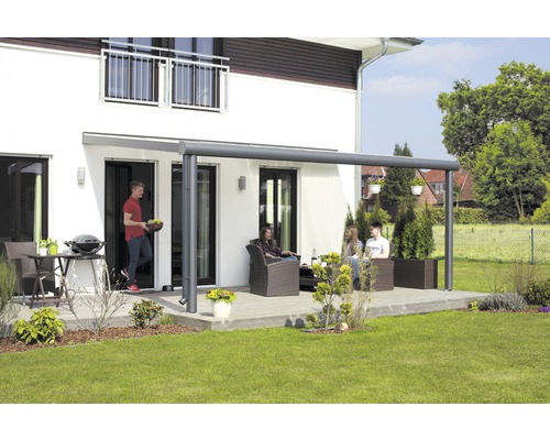 Terrasse avec toit de terrasse, mobilier de jardin et personnes devant une maison