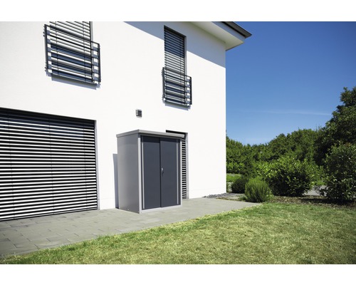 Abri de jardin en métal devant une maison avec jardin