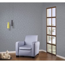 Salon avec fauteuil, suspensions, bougies et papier peint à motifs