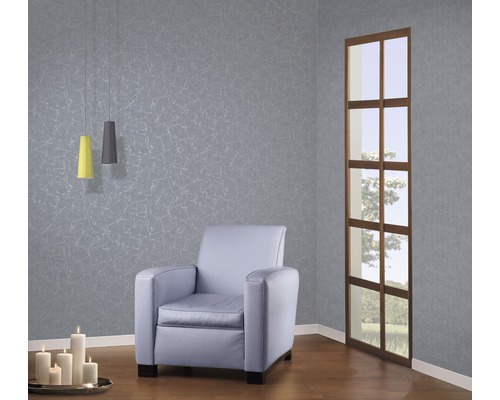 Salon avec fauteuil, suspensions, bougies et papier peint à motifs