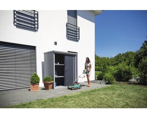 Scène de jardin avec armoire à outils, tondeuse à gazon et femme