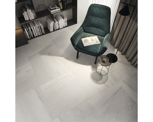 Pièce claire avec carrelage, fauteuil et étagère