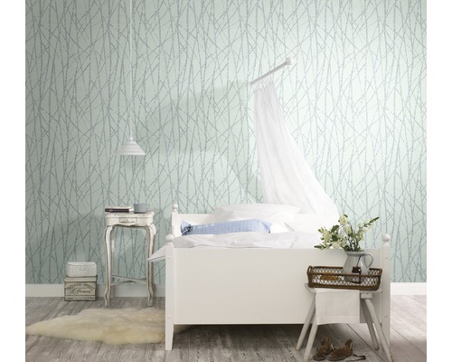 Chambre lumineuse avec lit blanc, table de chevet et papier peint à motifs