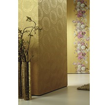 Raumansicht mit verschiedenen Tapetenmustern und einer Vase mit Zweigen.