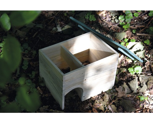 Maison en bois pour hérissons avec éléments de toit verts dans le jardin