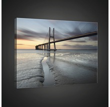 Leinwandbild mit einer Brücke über dem Meer bei Dämmerung