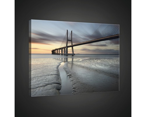 Leinwandbild mit einer Brücke über dem Meer bei Dämmerung