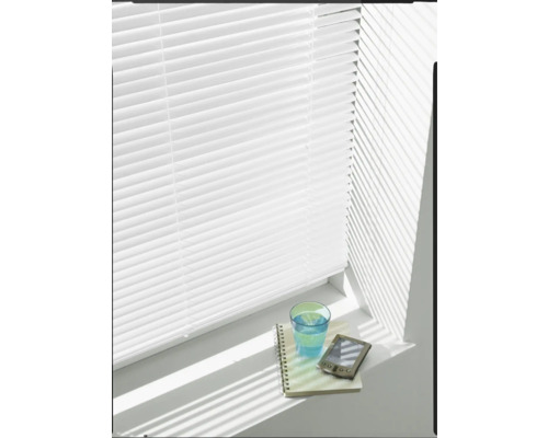 Weisse Jalousie vor Fenster mit Notizblock, Glas Wasser und elektronischem Gerät