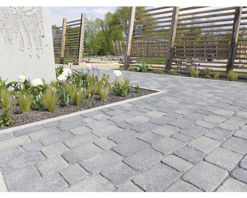 Chemin pavé avec des fleurs décoratives et des clôtures en bois dans le jardin