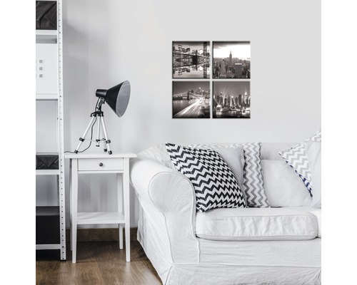 Wohnzimmer mit weißem Sofa, Beistelltisch mit Lampe und Wandbildern von New York