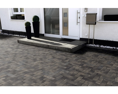 Allée avec des pavés en motif de chevrons devant une maison d''habitation.