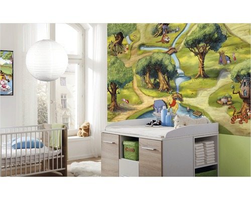 Chambre d''enfant avec papier peint Winnie l''ourson, lit de bébé et commode à langer pour équipement de bébé.