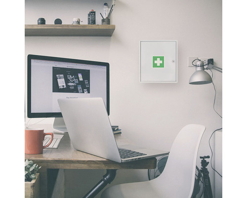 Bureau avec bureau, ordinateur et une armoire à pharmacie montée au mur.