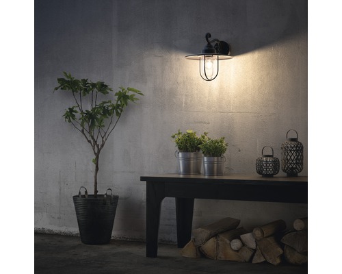 Beleuchtete Aussenwandleuchte neben Tisch mit Dekoration