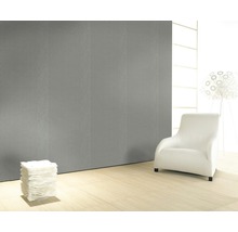 Pièce lumineuse avec panneau mural gris, fauteuil et lampe