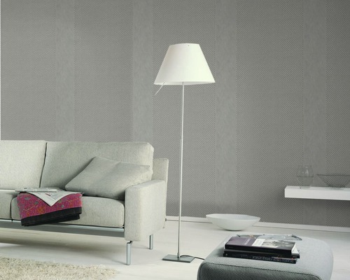 Salon avec canapé, lampadaire et papier peint à motifs