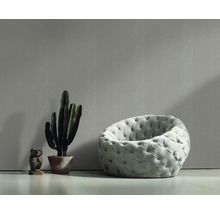 Pièce lumineuse avec papier peint à motifs, fauteuil, cactus et figurine décorative