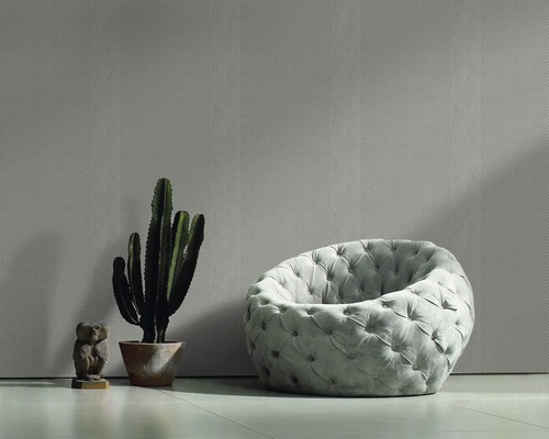 Pièce lumineuse avec papier peint à motifs, fauteuil, cactus et figurine décorative