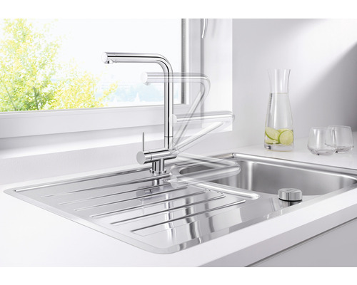 Robinet d''évier en acier inoxydable avec bec pivotant dans une cuisine lumineuse.