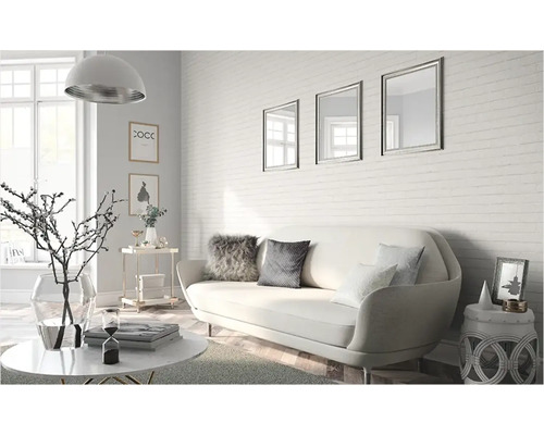 Salon avec canapé, table basse et accessoires décoratifs devant un mur en briques