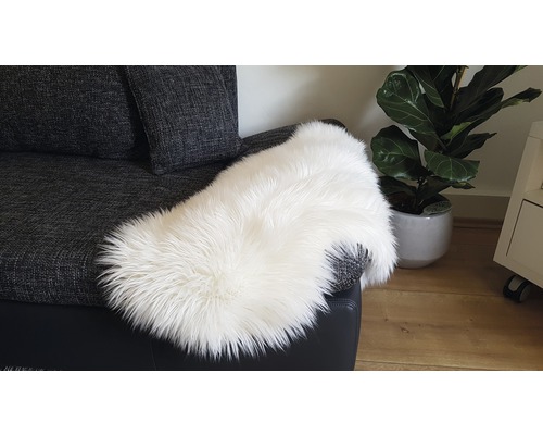 Peau de mouton blanche sur un canapé gris